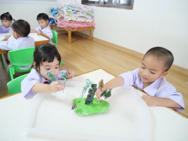 Two children on either side of the table, decorating their island together