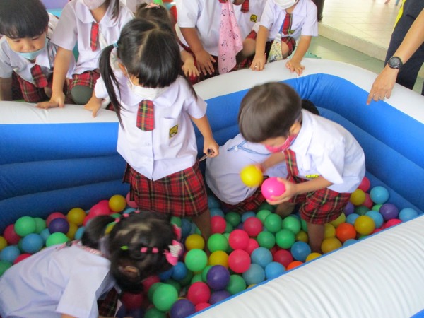 Children in the inflatable ball pit, picking up coloured balls
